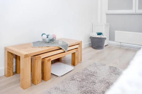 Houten tafel en weegschalen, wasmand met handdoeken. Interieur van witte stijlvolle kamer met wasmand — Stockfoto