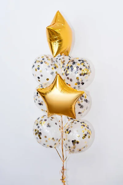 Beyaz arka planda farklı şekillerde metalik altın helyum balonları. Tatiller ve doğum günü partisi dekorasyonu — Stok fotoğraf