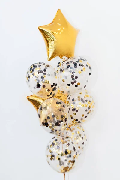 Metallic gouden helium ballonnen van verschillende vormen op een witte achtergrond. Vakantie en verjaardagsfeest decoratie concept — Stockfoto