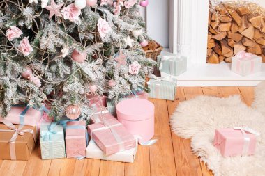 Güzel Noel hediye kutuları yerde, köknar ağacının yanında şömineli odada. Noel hediyeleri ve dekorasyon. Mutlu Kış Tatilleri