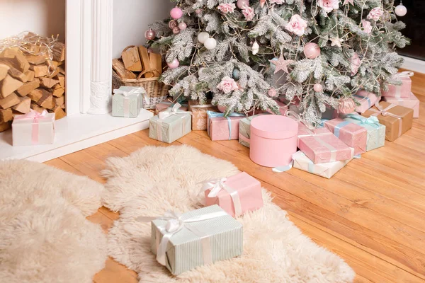 Belle scatole regalo di Natale al piano vicino abete in camera con camino. Regali di Natale e decorazione. Buone vacanze invernali — Foto Stock