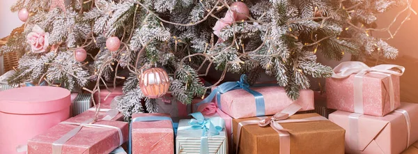 Caixas de presente de Natal bonitas no chão perto de abeto no quarto. Presentes de Natal e decoração. Boas férias de Inverno — Fotografia de Stock