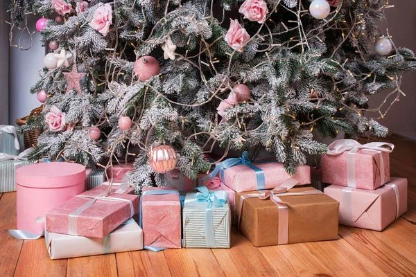 Caixas de presente de Natal bonitas no chão perto de abeto no quarto. Presentes de Natal e decoração. Boas férias de Inverno — Fotografia de Stock