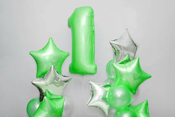 Dekoration för 1 år födelsedag, årsdag. Ett gäng gelformade gröna ballonger och stjärnor på ljus bakgrund. Symbolen för lycklig barndom, första födelsedagsfest. — Stockfoto