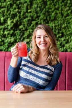 Sarışın, güzel kadın kafede limonata içiyor..