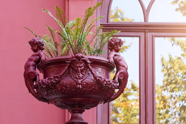 Escultura de macizo de flores de Cupido. Florero romano, florero con esculturas en el jardín botánico de Oporto, Portugal — Foto de Stock