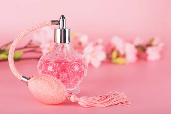 Transparante Parfumfles Met Lentebloeiende Boomtak Roze Ondergrond Aromatische Essence Fles — Stockfoto