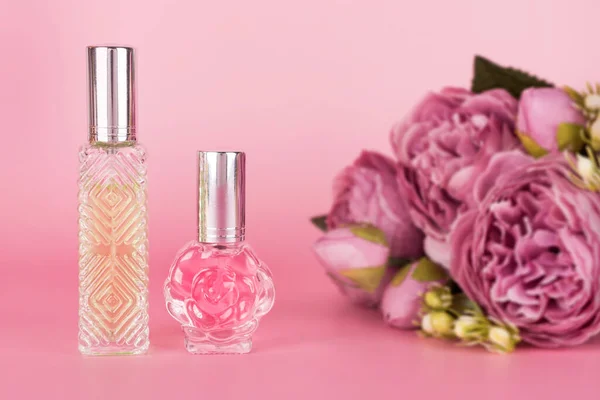 Diferentes Frascos Perfume Transparentes Con Ramo Peonías Sobre Fondo Rosa —  Fotos de Stock