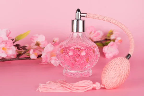 Transparante Glazen Parfumfles Met Lentebloeiende Boomtak Roze Ondergrond Aromatische Essence — Stockfoto