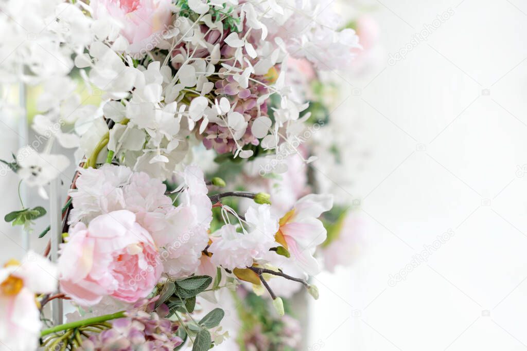 Flower wall, wedding backdrop, floral hand made decoration. Light background of artifical flowers. Vertical garden with peonies and hydrangeas. Elegant arrangement floristics setting. Copyspace