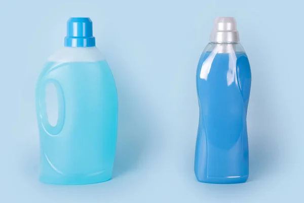 Botellas de detergente y suavizante de tela sobre fondo azul. Contenedores de productos de limpieza, productos químicos para el hogar. Detergente líquido para ropa y acondicionador. Lavandería, concepto de lavado y limpieza . — Foto de Stock