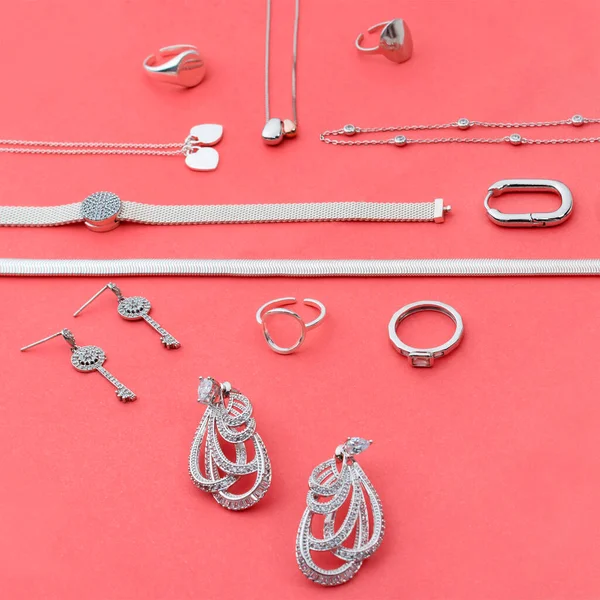 Joyería de plata sobre fondo rosa mínimo. Anillos, pulseras y pendientes. Vista superior de accesorios de mujer de moda, joyería y concepto de compras. Moderna composición geométrica geométrica minimalista . — Foto de Stock