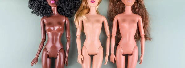 Plastic speelgoed poppen met verschillende huidtinten die diversiteit van rassen vertegenwoordigen. Het concept van gelijkheid, dieet, gewichtsverlies, positiviteit van het lichaam, vrouwelijke vriendschap, perfect lichaam, mode en schoonheid. — Stockfoto