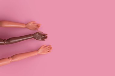 Pembe arka planda üç bebek eli. Farklı ten renkleri ve ırklar. Irkçılığı, çeşitliliği ve birliği, eşitliği ve feminizmi yaratıcı kavramı durdurun. Metin, üst görünüm ve düzen için yer