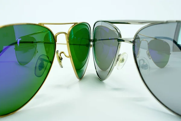 A pair of aviator sunglasses against each other, isolated on a w — Stock Photo, Image