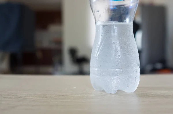 Bouteille d'eau douce à moitié vide avec gouttes . — Photo