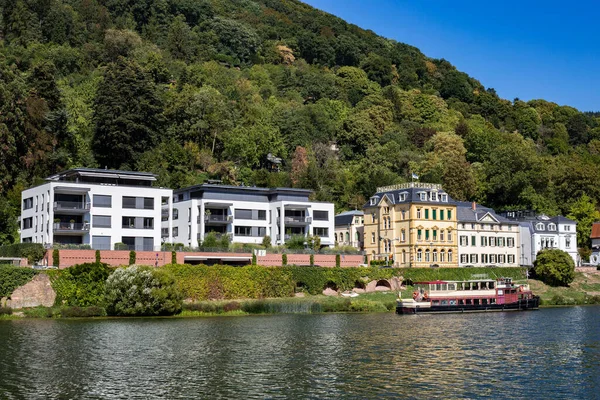 Modern houses on the river bank. Residential area near the old, famous city of Heidelberg, Germany. There is beautiful green forest around the area. Modern area near the historic city