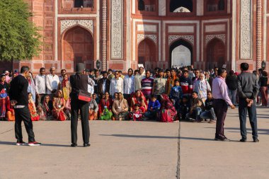 Agra, Up, India - 7 Mart 2019: Fotoğraf için Tac Mahal'in ana geçidinin önünde duran insanlar.