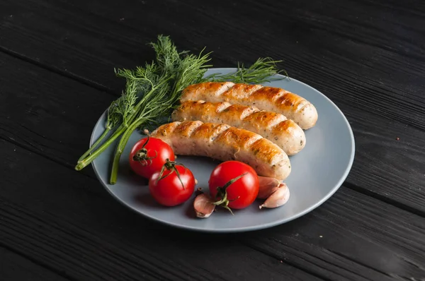 Drie Gegrilde Worstjes Een Grijze Plaat Een Houten Zwarte Achtergrond — Stockfoto