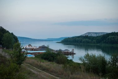 Evi su, Dinyester ve fiyortları kıyısında ağaçları ile arka planı. Yaz akşam, akşam gündoğumu. Bakota, Ukrayna