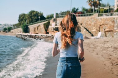 Genç kız deniz kumlu plaj yalınayak, kavram, görünümü arkadan çalışır