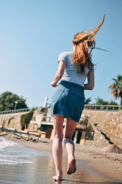 Genç kız deniz kumlu plaj yalınayak, kavram, görünümü arkadan çalışır