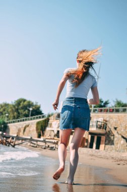 Genç kız deniz kumlu plaj yalınayak, kavram, görünümü arkadan çalışır