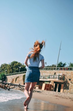 Genç kız deniz kumlu plaj yalınayak, kavram, görünümü arkadan çalışır