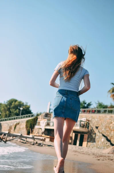 Genç kız deniz kumlu plaj yalınayak, kavram, görünümü arkadan çalışır