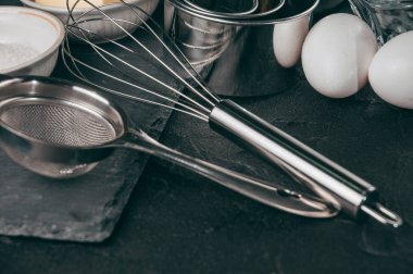 Un, üç tavuk yumurtası ve kayrak bir tahta malzemeler ve Corolla'yı da yattığı, yemekler siyah bir beton tablo dolu. Yukarıdan görüntüleyin. Metnin altında yer