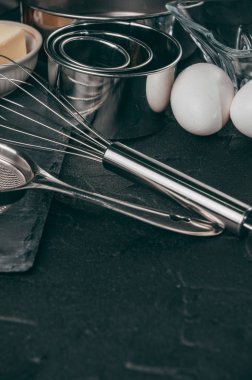 Un, üç tavuk yumurtası ve kayrak bir tahta malzemeler ve Corolla'yı da yattığı, yemekler siyah bir beton tablo dolu. Yukarıdan görüntüleyin. Metnin altında yer