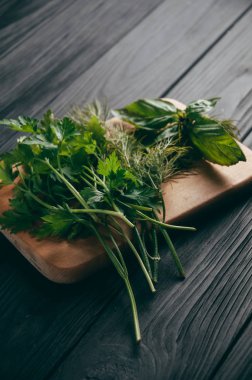 Otlar ve baharatlar bir gemide ahşap kahverengi, siyah ahşap zemin. Maydanoz dereotu. Yemek pişirmek için malzemeler. Üstten görünüm, altında metni metso