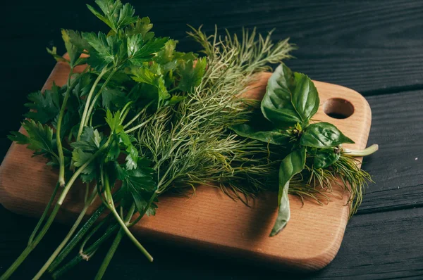 Otlar ve baharatlar bir gemide ahşap kahverengi, siyah ahşap zemin. Maydanoz dereotu. Yemek pişirmek için malzemeler. Üstten görünüm, altında metni metso