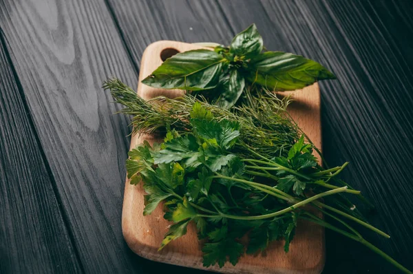 Otlar ve baharatlar bir gemide ahşap kahverengi, siyah ahşap zemin. Maydanoz dereotu. Yemek pişirmek için malzemeler. Üstten görünüm, altında metni metso