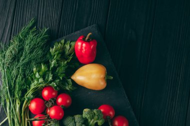Taze sebze: domates, brokoli, biber, dereotu, maydanoz koyu ahşap bir masa üzerinde. Tarifi. Malzemeler. Diyet yiyecek. Metnin altında yerleştirin. Yukarıdan görüntülemek