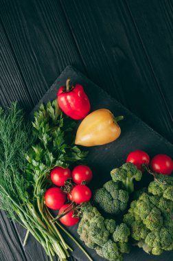 Taze sebze: domates, brokoli, biber, dereotu, maydanoz koyu ahşap bir masa üzerinde. Tarifi. Malzemeler. Diyet yiyecek. Metnin altında yerleştirin. Yukarıdan görüntülemek