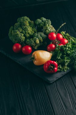 Taze sebze: domates, brokoli, biber, dereotu, maydanoz koyu ahşap bir masa üzerinde. Tarifi. Malzemeler. Diyet yiyecek. Metnin altında yerleştirin. Yukarıdan görüntülemek