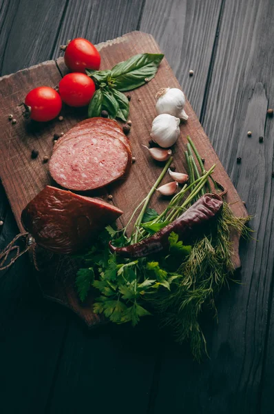 Salami Ahumado Sobre Una Mesa Negra Una Tabla Marrón Embutidos — Foto de Stock