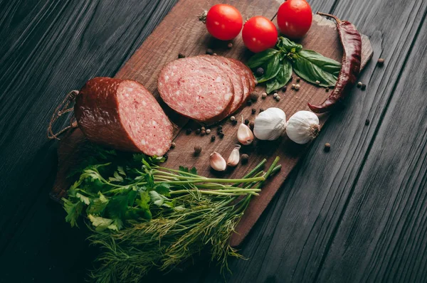 Salami Ahumado Sobre Una Mesa Negra Una Tabla Marrón Embutidos — Foto de Stock