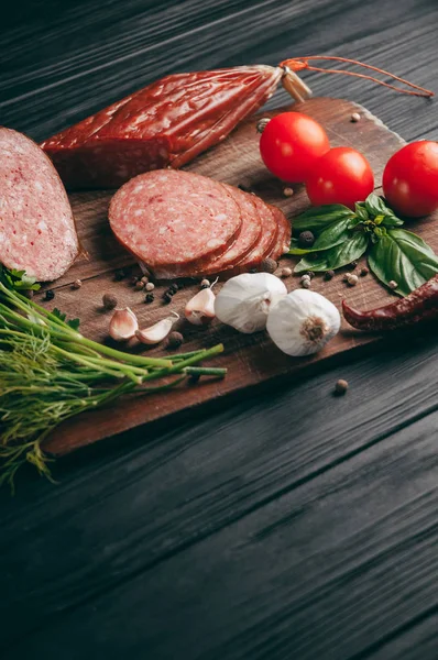 Salami Ahumado Sobre Una Mesa Negra Una Tabla Marrón Embutidos — Foto de Stock