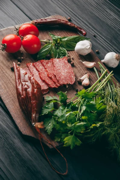 Salami Ahumado Sobre Una Mesa Negra Una Tabla Marrón Embutidos — Foto de Stock