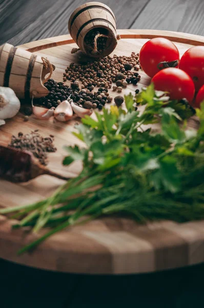 Baharatlar: kırmızı biber, kara biber, sarımsak, kimyon, kişniş, tatlı biber yalan bir kahverengi ahşap tahta siyah bir tablo üzerinde yuvarlak. Metnin altında yer