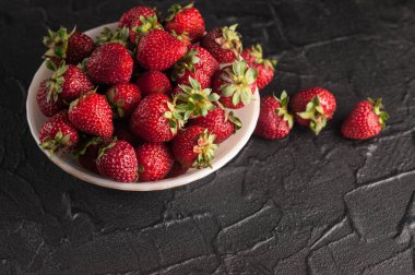 Siyah arka planda taze çilekler.