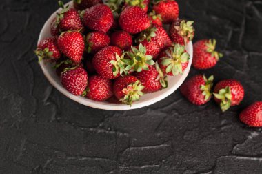 Siyah arka planda taze çilekler.