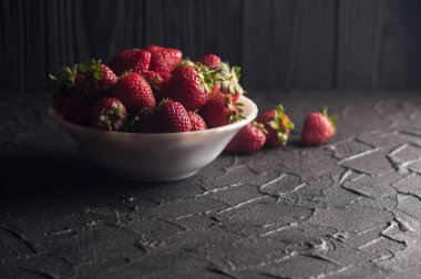 Siyah arka planda taze çilekler.