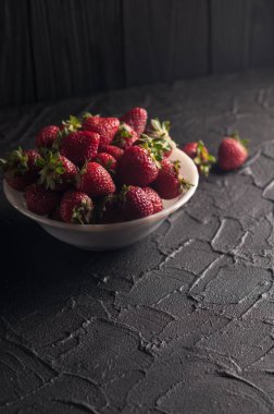 Siyah arka planda taze çilekler.