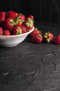 Siyah arka planda taze çilekler.