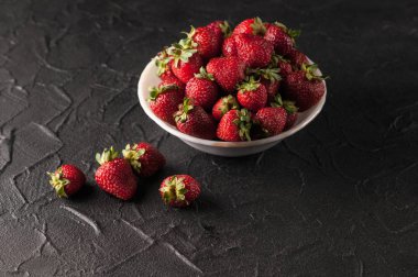 Siyah arka planda taze çilekler.