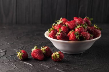 Siyah arka planda taze çilekler.