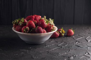 Siyah arka planda taze çilekler.